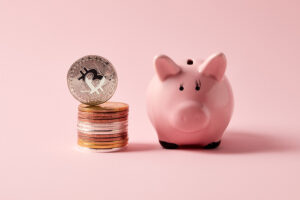 stack of bitcoins and piggy bank on pink