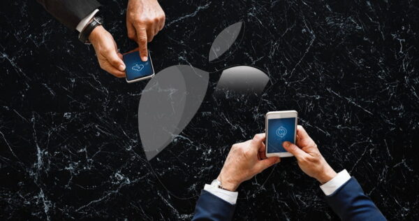 Two people in suits holding smartphones over a black marble surface with a large, semi-transparent Apple logo in the background.