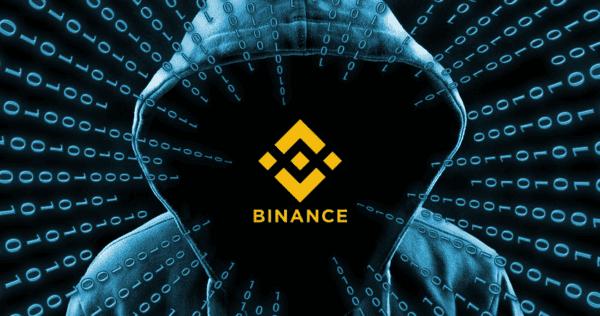 A hooded figure with a shadowed face is surrounded by binary code, with the Binance logo and the word 