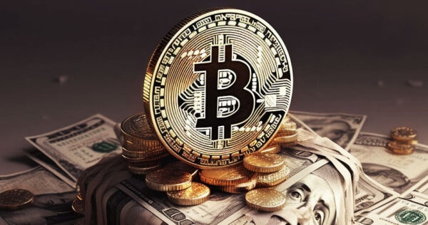 A gold Bitcoin coin stands upright on a pile of U.S. dollar bills and scattered coins.