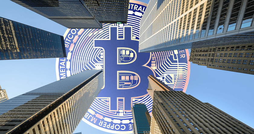 Skyscrapers surround a large, digitally rendered Bitcoin symbol overlaying the sky above, blending cryptocurrency imagery with a cityscape view.