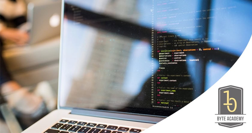 A laptop displays colorful lines of code on the screen, with a blurred background and the Byte Academy logo in the foreground.