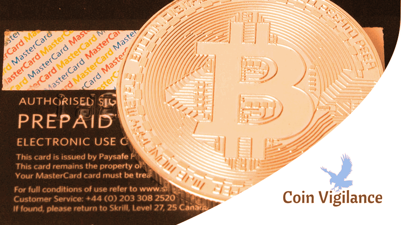 A physical Bitcoin token rests on top of a prepaid MasterCard, with the Coin Vigilance logo visible in the corner.