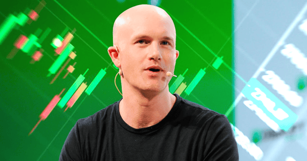 A bald man wearing a black t-shirt and a headset microphone speaks in front of a green background with financial chart graphics.