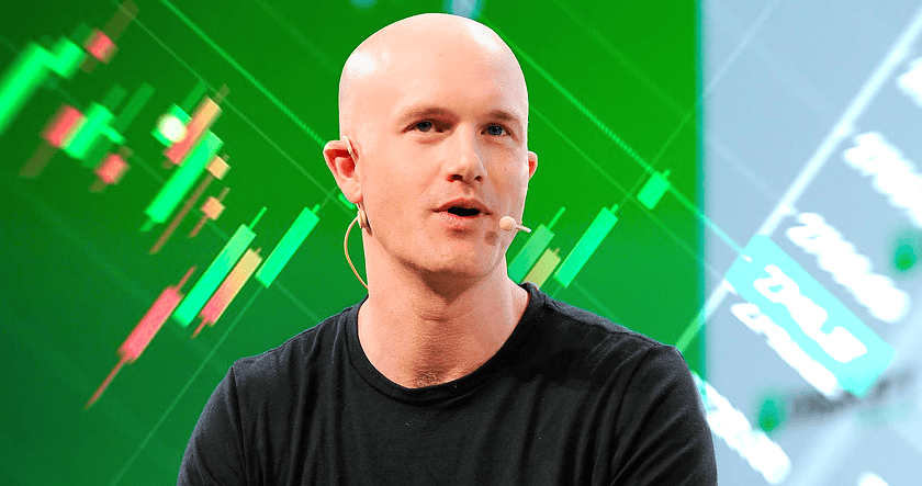 A bald man wearing a black t-shirt and a headset microphone speaks in front of a green background with financial chart graphics.