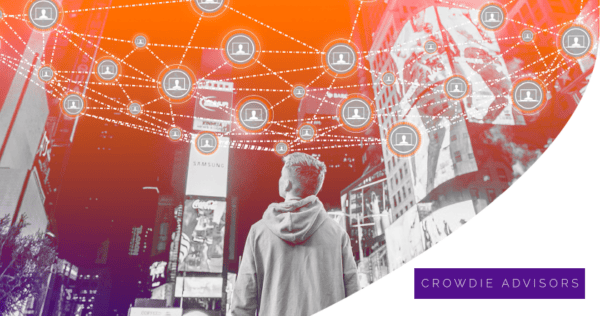 A person stands in a cityscape looking up at a digital network of connected laptop icons, with 