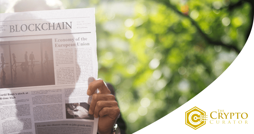 A person holds a newspaper featuring an article on blockchain and the economy of the European Union; "The Crypto Curator" logo appears in the bottom right corner.