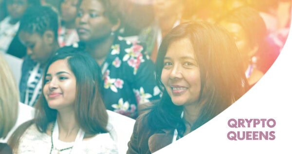 A diverse group of women attend a conference, with one woman in the foreground smiling at the camera. The text 