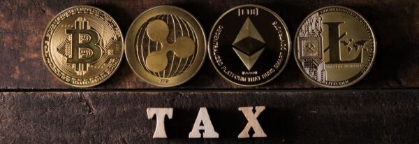 Four different cryptocurrency coins (Bitcoin, Ripple, Ethereum, Litecoin) are displayed above wooden letters spelling 