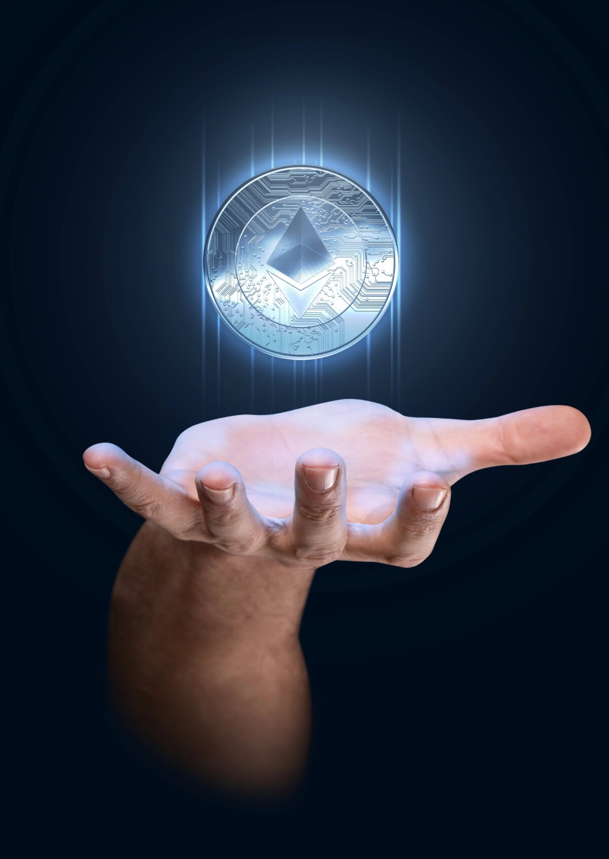A human hand is held open with the palm facing up, appearing to levitate a glowing silver Ethereum coin against a dark blue background. Light radiates from the coin, highlighting the digital currency symbol.