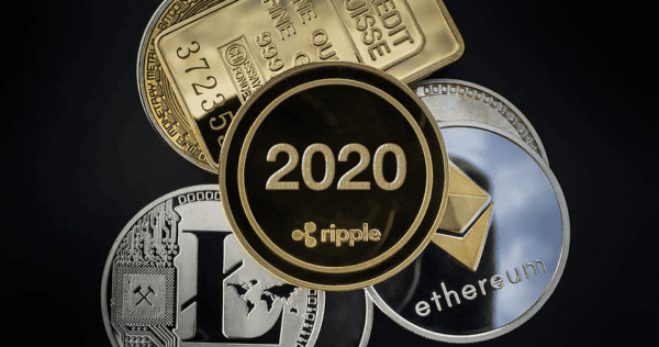 Various coins representing cryptocurrencies (Ripple, Litecoin, Ethereum) and a gold credit suisse bar are arranged with a “2020” Ripple coin in the center.