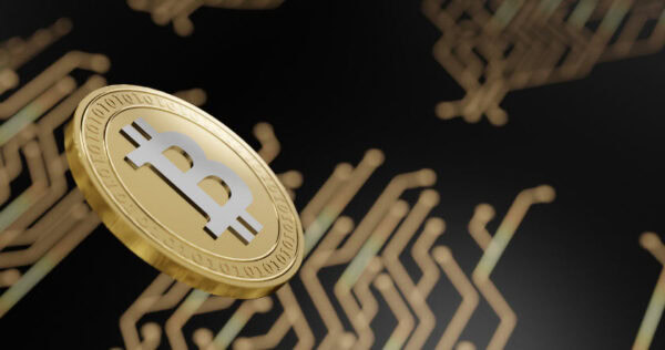 A gold-colored Bitcoin coin hovers over a blurred background with circuit-like patterns.