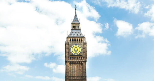 Big Ben clock tower with a stylized yellow and black emblem on its clock face, under a partly cloudy sky.