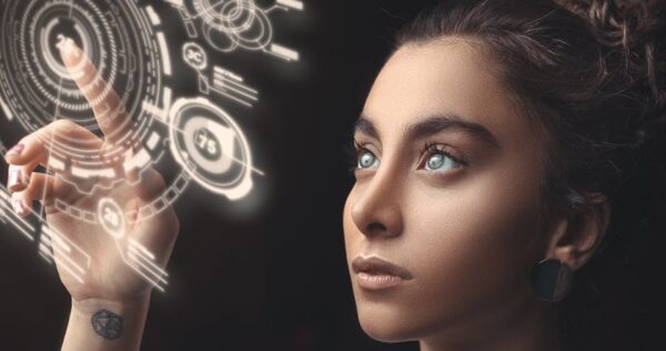 A woman with light eyes touches a glowing, futuristic virtual interface with her finger, displaying digital circular graphics and data.