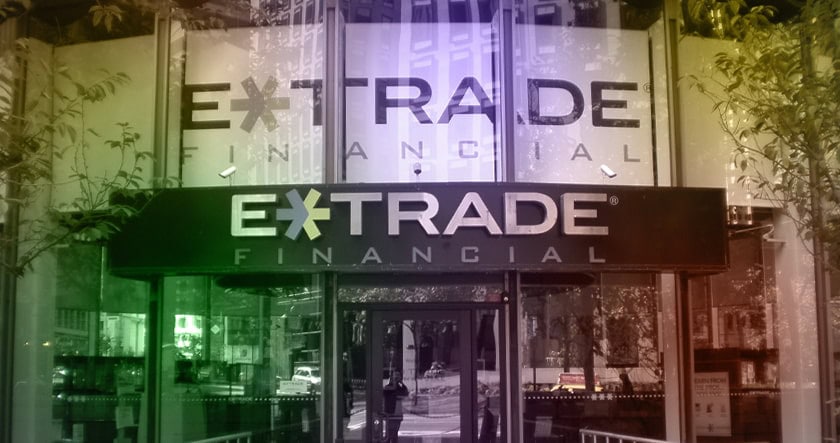 Exterior view of an E*TRADE Financial office entrance with large company signage on the windows and above the door.