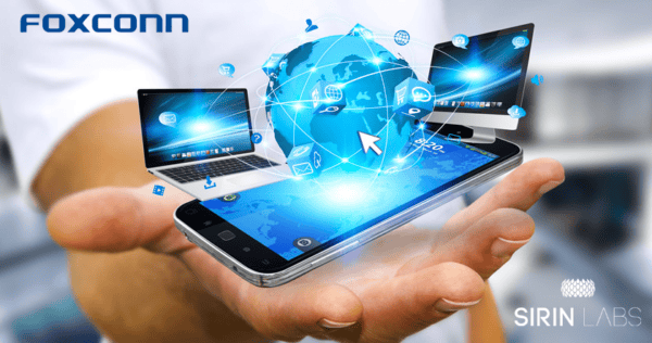 A hand holding a smartphone with holographic digital icons, a globe, and laptops, showing global connectivity; Foxconn and Sirin Labs logos are visible.