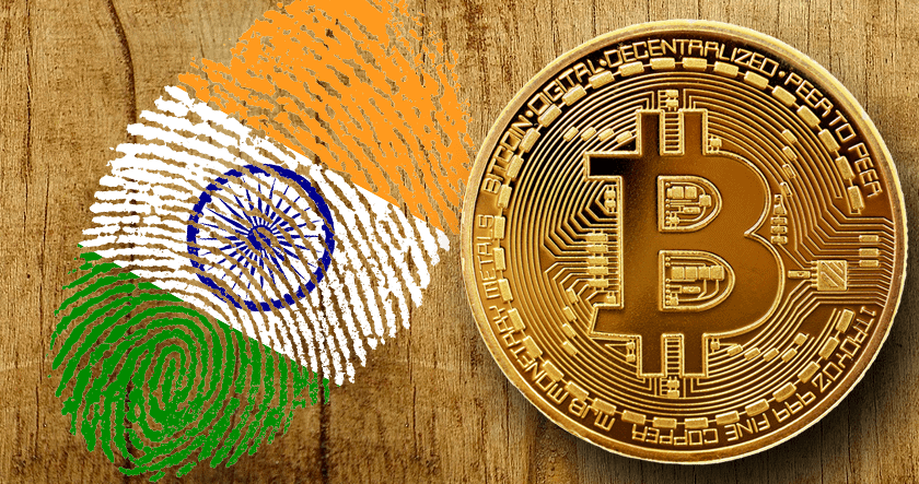 An Indian flag fingerprint and a Bitcoin coin are placed side by side on a wooden surface.