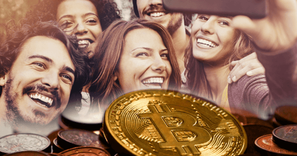 A group of smiling people take a selfie, with a large image of a Bitcoin coin and other coins overlaid in the foreground.