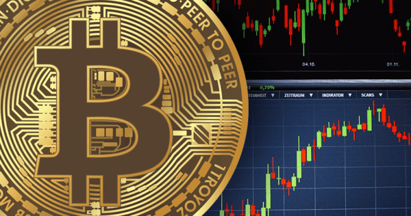 A close-up of a Bitcoin symbol overlaid on a background showing candlestick charts and trading data on a computer screen.