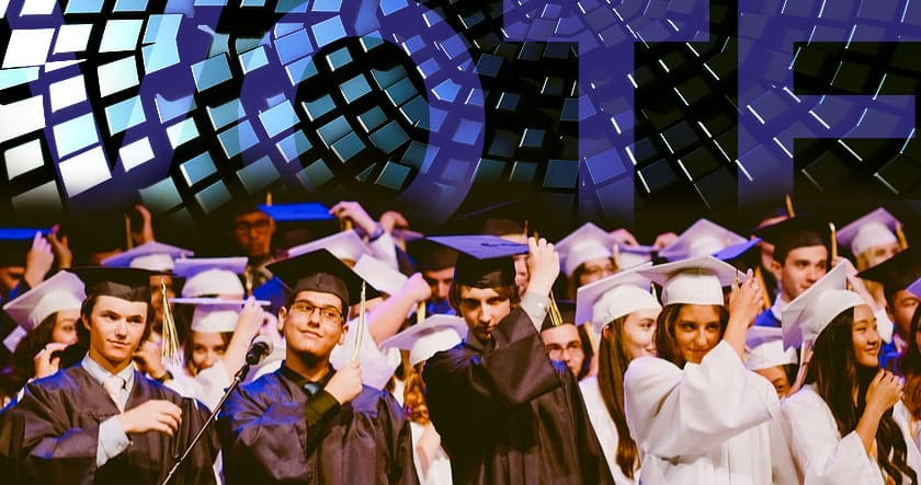 A group of graduates in caps and gowns stands together on stage, adjusting their tassels, with a digital "VOTE" graphic displayed above them.