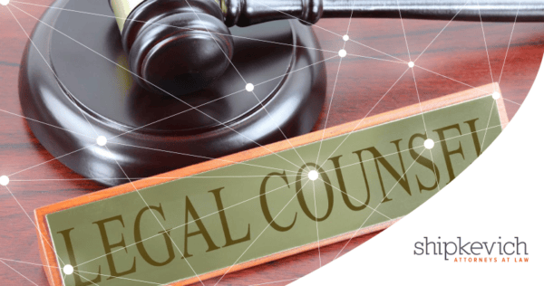 A judge's gavel rests on a sound block next to a nameplate reading 